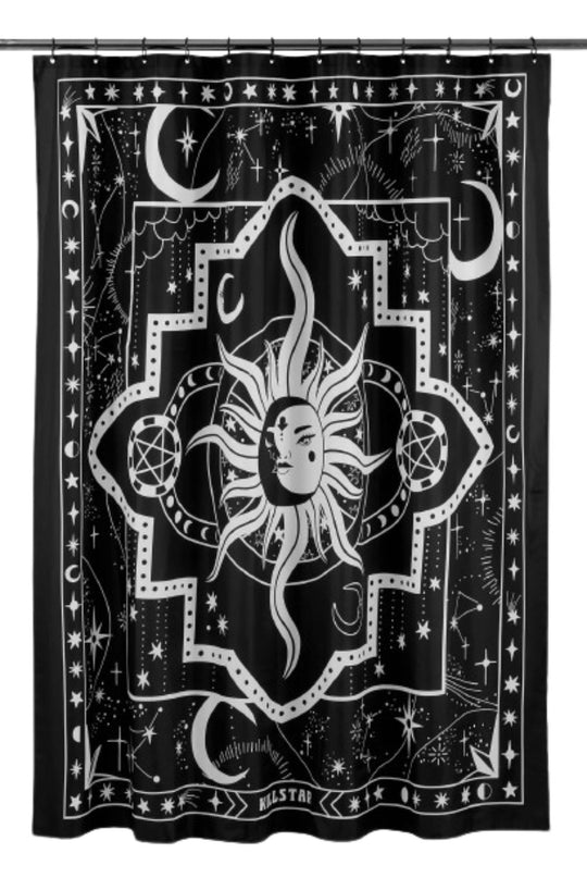 A black and white shower curtain with a white sun hanging on a shower rod.