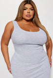 A plus size female wearing a heather grey midi dress. Stylish and versatile garment that falls below the knees, perfect for any occasion.