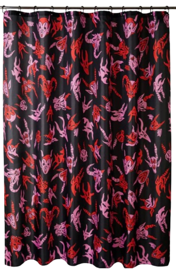 A black shower curtain with red and pink characters on it hanging from a shower rod.