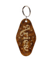 A brown marble keychain with the word “ Aries “ written in gold on it.