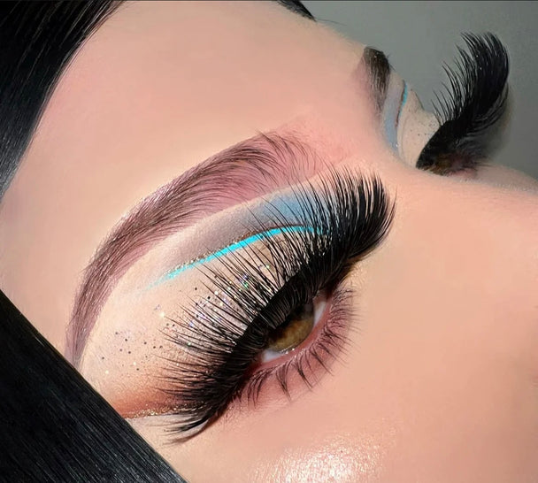 A close up of a woman’s face and eyes wearing bold vibrant eyeshadow and a pair of Forever Lashed Premium 3d mink - 25mm false eyelashes.