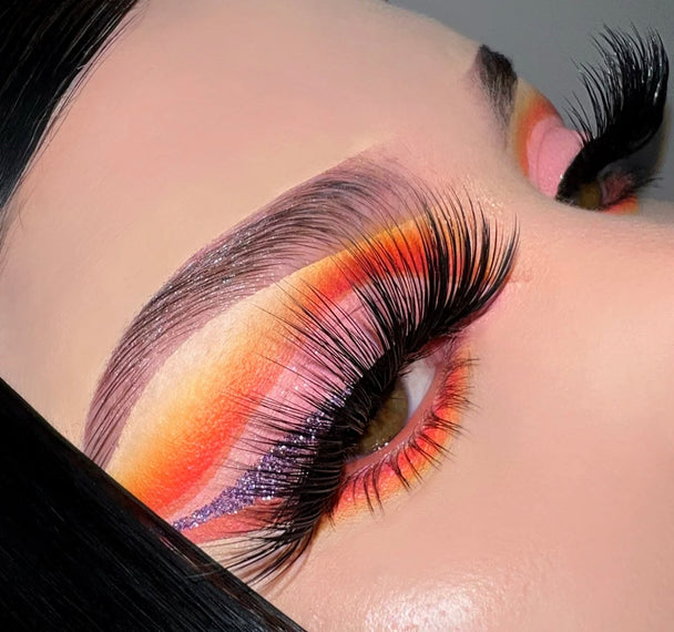 A close up of a woman’s face wearing Angel of Mine Premium 3d Mink - 25mm false lashes and bold eyeshadow.