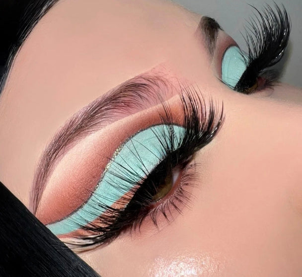A close up of a woman’s face and eyes wearing Bad Vibes Premium 3d Mink - 25mm false eyelashes with  bold vibrant eyeshadow.