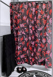 A black shower curtain with red and pink characters on it hanging on a shower rod in a bathroom.