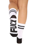 A woman wearing a pair of white striped crew socks with the graphic “ Fuck “ written on the bottom.