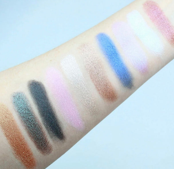 A close-up of a arm displaying ten eyeshadow shades.