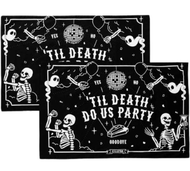 A pair of black pillowcases with white text and skeletons.