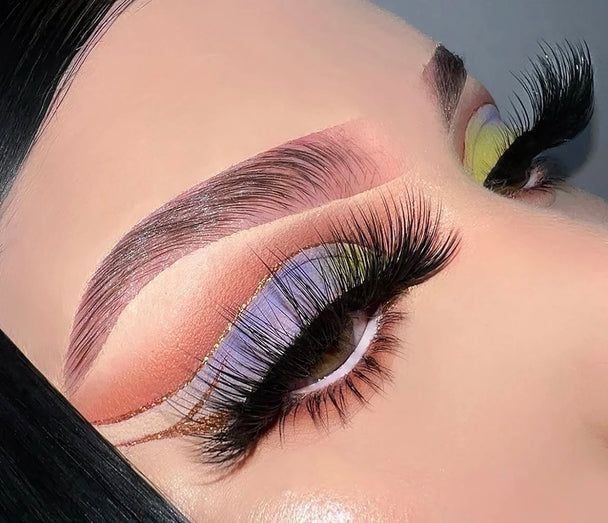 A close up of a woman’s face wearing bold eyeshadow and a pair of Catching Feelings Premium 3d Mink - 25mm false eyelashes.