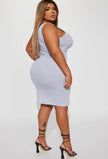 Side view of a plus size woman wearing a heather grey midi dress. Stylish and versatile garment that falls below the knees, perfect for any occasion.
