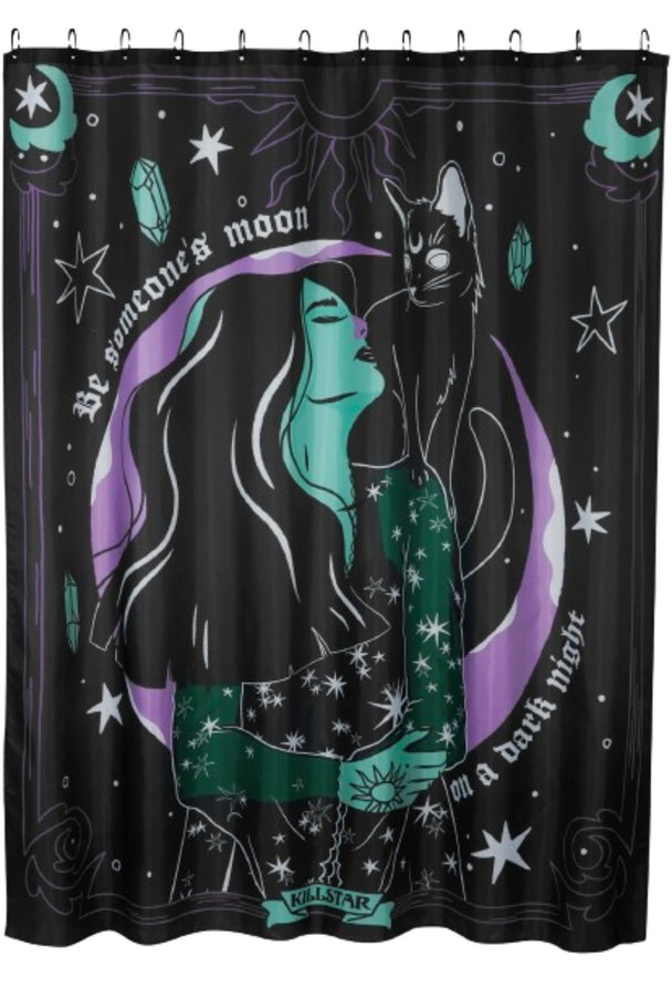 A black shower curtain with white text, a woman, cat, moon and stars hanging on a shower rod.